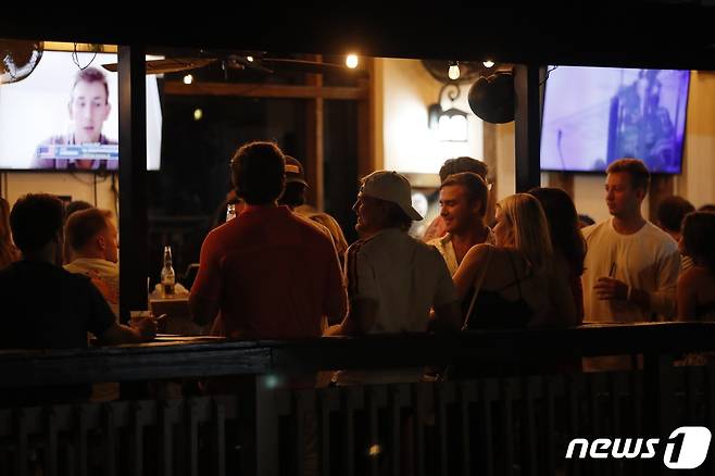 25일(현지시간) 식당과 술집 영업이 완전히 허용된 플로리다에 있는 한 바에서 시간을 보내는 사람들. © AFP=뉴스1