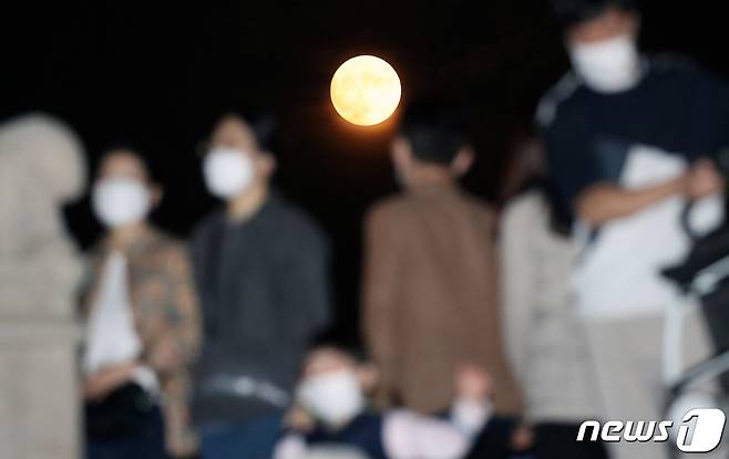 민족대명절 추석인 1일 밤 서울 종로구 경복궁에서 마스크를 쓴 시민들이 보름달을 바라보고 있다. 2020.10.1/뉴스1 © News1 송원영 기자