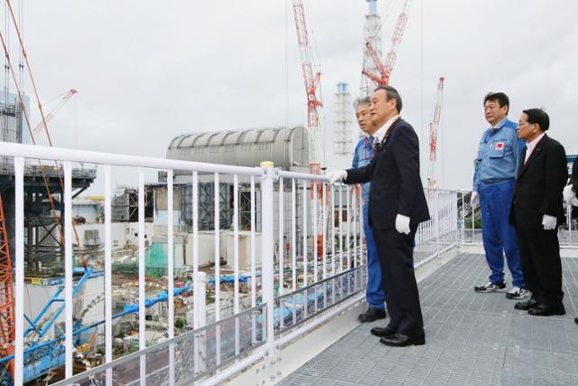 스가 요시히데 일본 총리가 지난달 26일 첫 지방 출장지로 후쿠시마 제1 원자력발전소를 방문해 오염수 처리 등에 대해 도쿄전력 관계자로부터 설명을 듣고 있다. 후쿠시마=AFP 연합뉴스