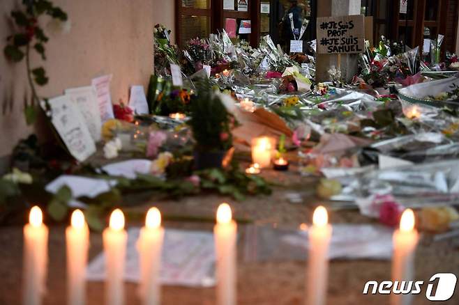 참수된 채 발견된 프랑스 교사 사뮤엘 프티가 재직하던 중학교에 그를 추모하는 촛불과 꽃이 놓여있다. © AFP=뉴스1