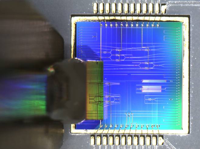 ETRI 연구진이 실리콘 광집적회로 칩에 입출력 다채널 광섬유를 결합 실장하는 모습.[ETRI 제공]