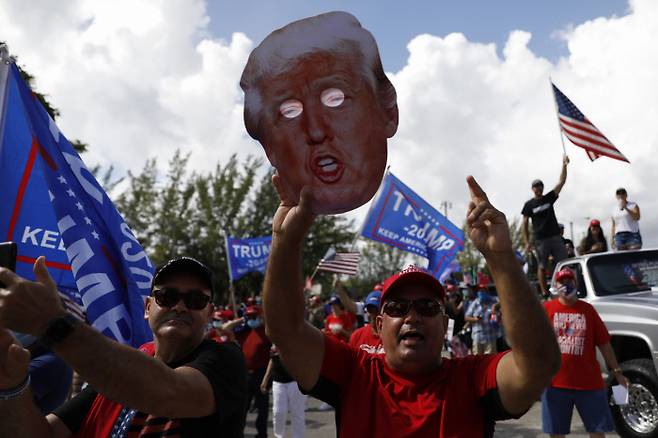 지난 1일(현지시간) 미국 마이애미 유세현장에서 한 유권자가 도널드 트럼프 대통령의 얼굴 모형을 들고 있다. 마이애미|AP연합뉴스