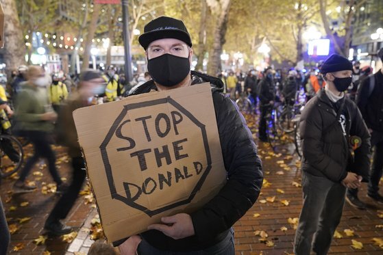 시애틀의 한 바이든 지지자는 "도널드는 그만(Stop the Donald)"이라는 플래카드를 들고 있다. AP=연합뉴스