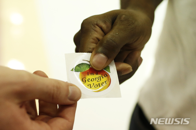 [애선스=AP/뉴시스] 3일(현지시간) 조지아주 애선스의 유권자가 투표를 마친 후 투표 확인 스티커를 받고 있다. 2020.11.05.