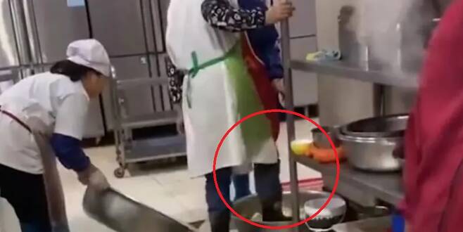 중국 우한 동호학원 관계자가 신발을 신은 채 발로 배추를 씻는 모습. /사진=바이두 갈무리