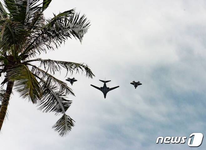 B-1랜서(가운데) 양 옆으로 F-22랩터 전투기 2대가 11일(현지시간) 미 재향군인의날을 맞아 괌 상공에서 편대 비행을 실시하고 있다. /출처=미태평양공군사령부© 뉴스1