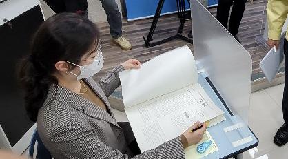 부산시교육청 직원이 지난 19일 반투명 칸막이가 설치된 책상에서 시험을 치르는 장면을 시연하고 있다. 연합뉴스