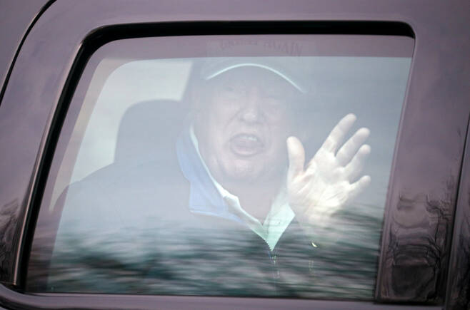 도널드 트럼프 미국 대통령이 22일(현지시간) 버지니아주에 위치한 트럼프 내셔널 골프 클럽으로 이동하는 차량 안에서 지지자를 향해 손을 흔들고 있다. [로이터]