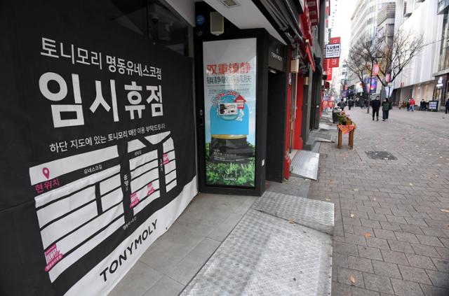 코로나19 일일 확진자가 500명을 넘어선 가운데 26일 오후 서울 중구 명동거리에 지나는 사람이 없어 한산한 가운데 한 화장품 가게가 임시 휴점을 알리는 프래카드를 내걸었다. 홍인기 기자