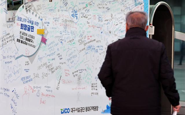 신종 코로나바이러스 감염증(코로나19) 극복 메시지가 적힌 희망글판이 설치된 23일 오전 대구 동구 동대구역 광장을 시민이 지나고 있다. 뉴시스