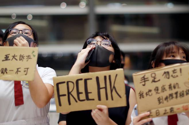 지난 2019년 홍콩 반정부 시위에 참석한 학생들이 피켓을 들고 구호를 외치는 모습. [로이터]