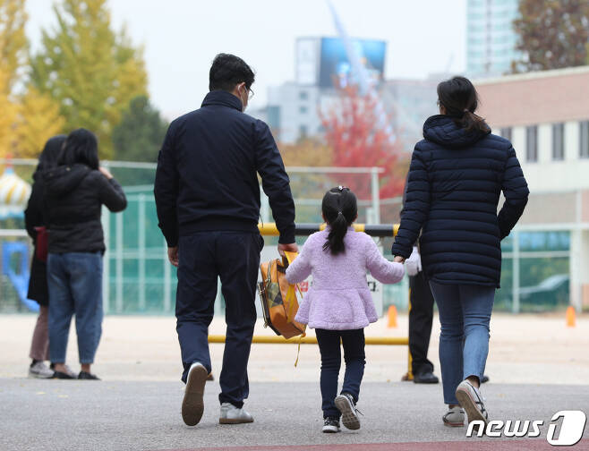 서울 한 초등학교에서 학생이 부모 손을 잡고 등교하고 있다. 2020.11.6/뉴스1 © News1 신웅수 기자