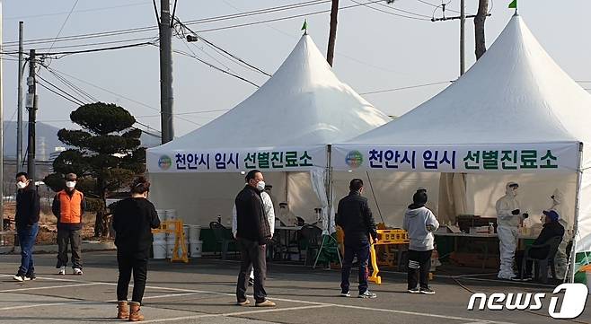 천안 병천면 행정복지센터에 주민들과 외국인 노동자들이 검사를 받기 위해 줄을 서있다.© 뉴스1