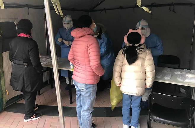 (베이징=연합뉴스) 김윤구 특파원 = 26일 베이징 차오양구 왕징의 아파트 안에서 한 어린이가 핵산검사를 받고 있다.