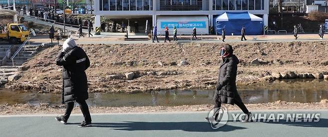 주말 산책과 선별검사 대기 (서울=연합뉴스) 한상균 기자 = 20일 은평구 임시선별검사소에서 시민들이 차례를 기다리고 있다. 그 앞으로 산책 나온 사람들이 홍제천을 걷고 있다. 2020.12.20 xyz@yna.co.kr