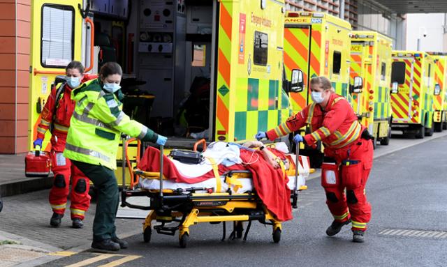 코로나19 확산으로 비상이 걸린 영국 런던의 '로열 런던 병원'에서 3일 의료진이 구급차에 실려 온 환자를 병원으로 옮기고 있다. 런던=EPA 연합뉴스