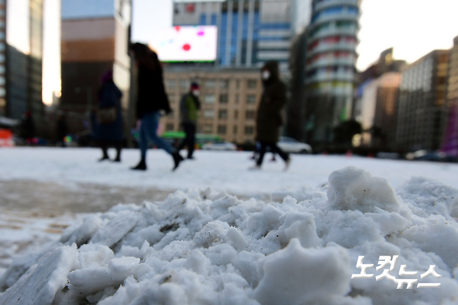 전국 대부분 지역에 한파특보가 내려진 7일 오전 서울 광화문역 인근에서 시민들이 밤사이 내린 눈으로 얼어붙은 길을 따라 출근길을 재촉하고 있다. 황진환 기자