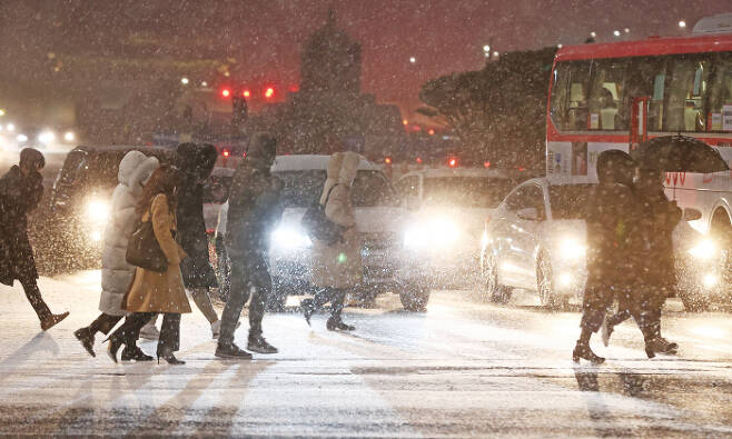 서울 전역에 대설주의보가 발효된 6일 저녁 서울 광화문역 인근에서 시민들이 퇴근길을 재촉하고 있다. 연합뉴스