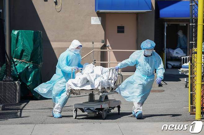 미국 뉴욕 브루클린에 있는 와이코프병원에서 2020년 4월 6일 코로나19 감염으로 인한 사망자의 시신이 임시 영안실 역할을 하는 냉장 트럭으로 옮겨지는 모습.  © AFP=뉴스1