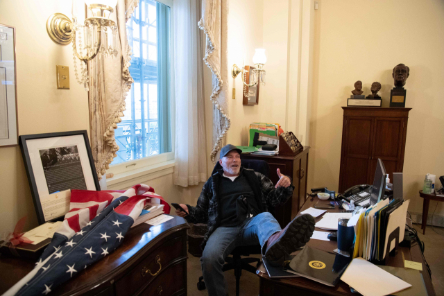 미국 국회의사당에 난입한 도널드 트럼프 대통령 지지 시위대 한 명이 6일(현지시간) 낸시 펠로시 하원의장 사무실까지 들어와 의자에 앉아 발을 책상 위에 올리고 있다./연합뉴스