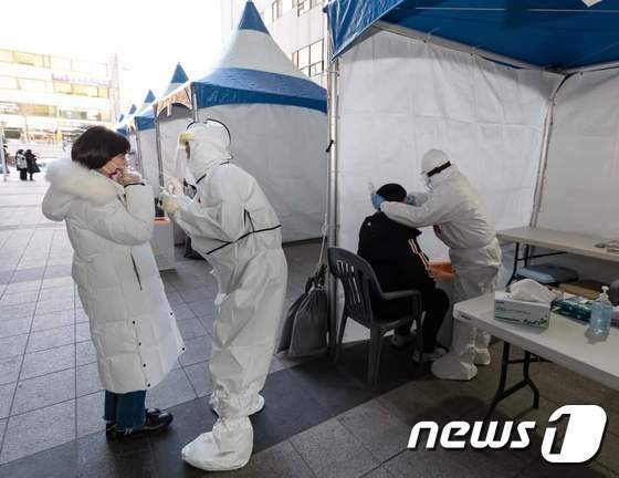 수원시청 본관 건물과 별관 건물 사이에 설치된 신종 코로나바이러스 감염증(코로나19) 임시검사소에서 검체 채취를 받고 있는 시청 직원들. / 사진=뉴스1
