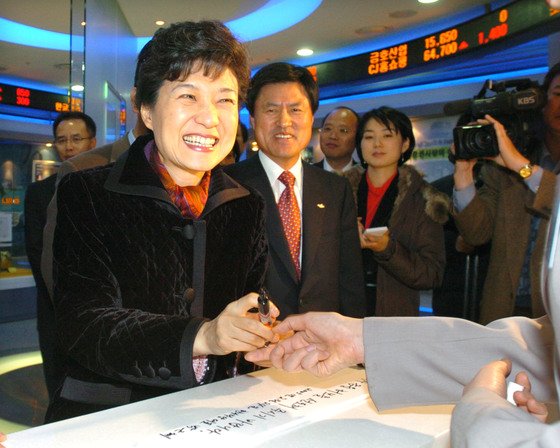 2005년 박근혜 당시 한나라당 대표가 부산 증권선물거래소를 방문,`동북아 물류 허브를 선도해 주시기 바랍니다`라는 글을 적은 뒤 환하게 웃고 있다. 중앙포토