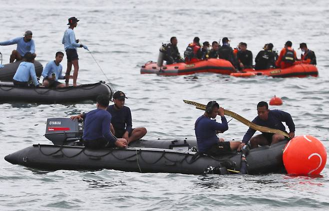 인도네시아 스리위자야항공 여객기가 추락한 것으로 추정되는 자카르타 인근 해상에서 10일 해군 잠수부들이 사고 항공기 잔해를 수습하고 있다.  AP연합뉴스