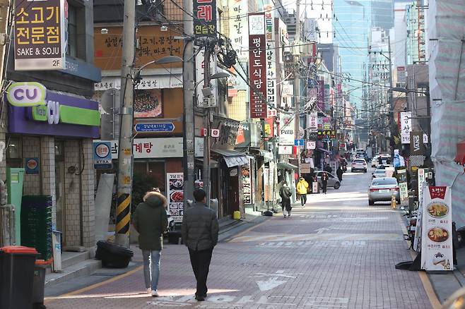 Pedestrians walk through the quiet Gangnam district in Seoul on Dec. 14. (Yonhap)