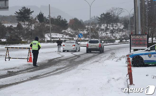 대설특보가 내려진 지난 7일 오전 제주시 아라동 제주대학교 앞 사거리에서 자치경찰이 차량통제를 하고 있다.2021.1.7 /뉴스1 © News1 오현지 기자