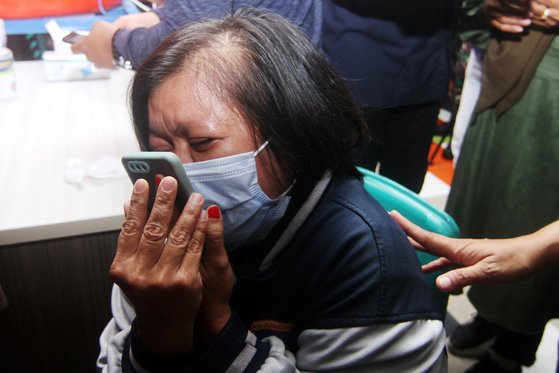 9일(현지시간) 해상에 추락한 인도네시아 스리위자야 여객기 탑승객의 가족이 10일 사고 해상 인근 부두에서 눈물을 흘리며 구조 소식을 기다리고 있다. [로이터=연합뉴스]
