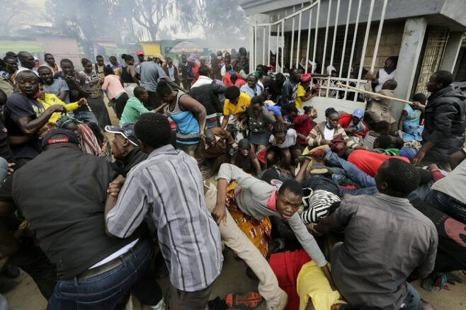 지난 4월10일 케냐 나이로비의 한 빈민가에서 사람들이 경찰이 쏜 최루탄을 피해 달아나고 있다. AP연합뉴스