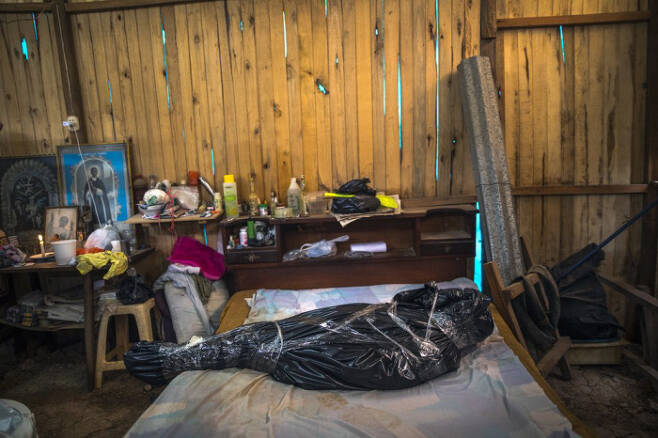 2020년 9월 페루 우카얄리 지역의 한 주택에서 코로나19로 사망한 거주민의 시신이 검은 비닐과 테이프로 꽁꽁 묶인 채 침대 위에 놓여있다. AP