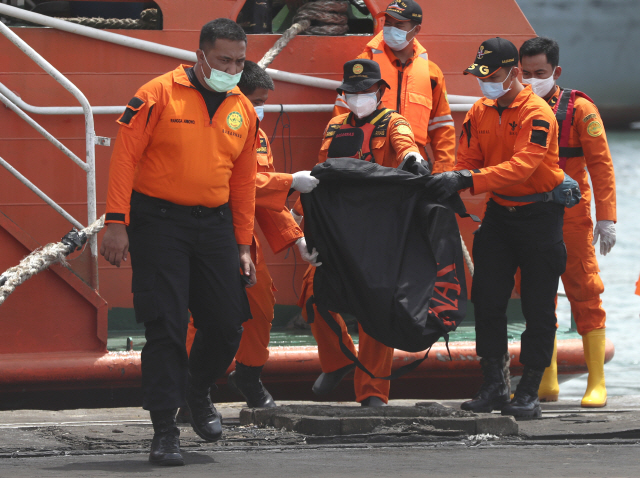 인도네시아 당국 관계자들이 사고기 잔해를 수거하고 있다. /AP연합뉴스
