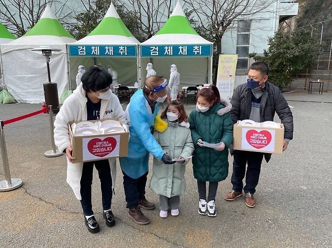 부산 사하구 다대동 롯데캐슬몰운대아파트 주민과 어린이들이 11일 다대동 옛 쓰레기소각장 주차장에 설치된 임시 선별검사소를 찾아 위로 손편지와 물품을 전달하고 있다. /사하구청