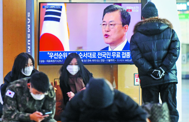 시민들이 11일 서울역 대합실에서 문재인 대통령이 청와대에서 2021년 신년사를 발표하는 모습을 방송 화면을 통해 보고 있다. 서영희 기자
