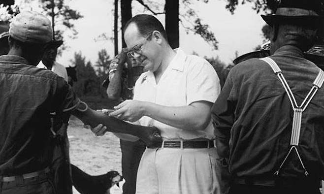 미국 앨라배마주 터스키기에서 흑인 환자들의 혈액을 채취하는 백인 의사의 모습. 이 흑인들은 자신이 비밀 생체실험의 대상이 된 줄을 모르고 있었다.