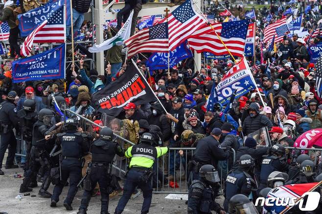 6일(현지시간) 도널드 트럼프 미국 대통령을 지지하는 시위대가 미 연방의회 의사당으로 몰려들면서 경찰과 충돌을 하고 있다. © AFP=뉴스1