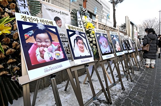 16개월 된 입양 딸 정인양을 학대해 숨지게 한 혐의를 받는 양부모에 대한 첫 공판이 열린 13일 서울 양천구 남부지방법원 앞에 학대로 숨진 아동들의 사진이 걸려 있다. 김성룡 기자