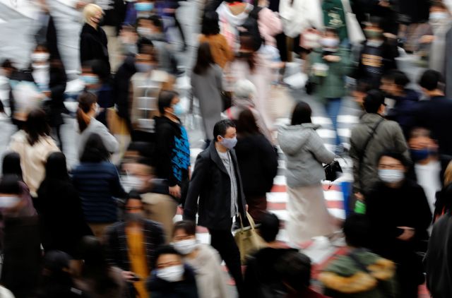 일본 도쿄에서 시민들이 마스크를 쓴 채 걷고 있다. 로이터 연합뉴스