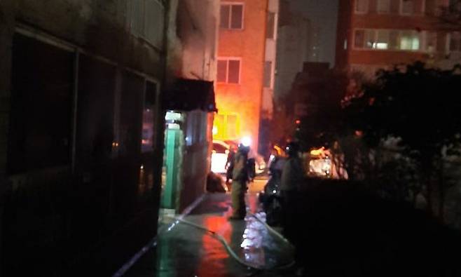 전기장판 과열로 추정되는 불이 난 빌라에 소방대원이 화재를 진화하고 있다. 부산 동래경찰서 제공