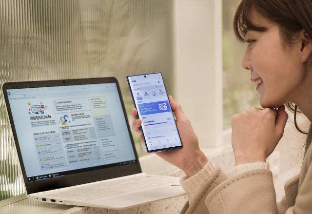 이동통신사 직원이 13일 패스(PASS) 인증서를 이용해 국세청 연말정산 서비스에 접속하는 시범을 보이고 있다.15일부터 패스인증서를 이용하는 고객은 국세청 홈택스 사이트에서 ‘간편인증 로그인’을 선택한뒤 ‘패스인증서’를 골라 간편하게 접속할 수 있다.