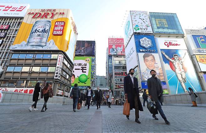 일본에서 코로나 바이러스 감염증 긴급사태가 확대 선포된 13일 오사카의 한 거리를 행인들이 오가고 있다. /AFP 연합뉴스