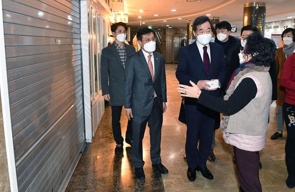 이낙연 대표가 14일 서울 영등포 지하상가 내 문을 닫은 상가 앞에서 상인들의 고충을 듣고 있다. /연합뉴스