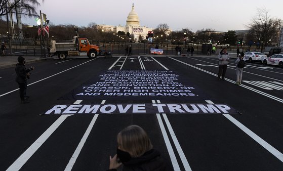 도널드 트럼프 미 대통령에 대한 하원의 탄핵소추안 표결이 진행된 13일(현지시간) 의사당이 보이는 도로 한 가운데에 "트럼프를 제거하라"는 글자가 적혀있다.[EPA=연합뉴스]