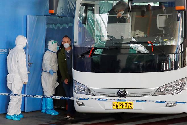 코로나19 바이러스의 기원을 조사할 세계보건기구(WHO) 국제조사단이 14일 중국 후베이성 우한의 톈허국제공항에 도착해 버스에 오르고 있다. 우한 | 로이터·연합뉴스