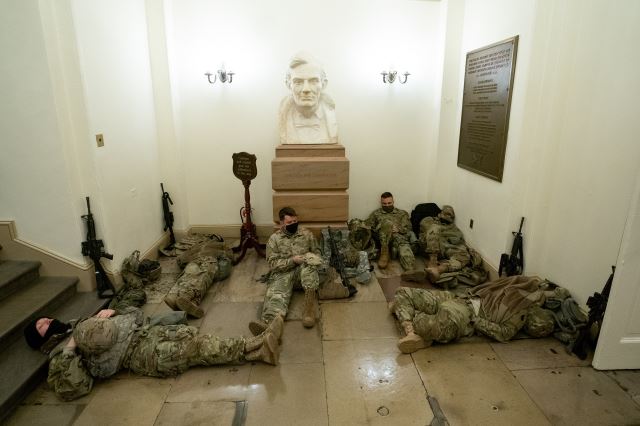 미국 국회의사당 내 링컨 전 대통령 흉상 아래서 총기로 무장한 주방위군들이 휴식을 취하고 있다. UPI연합뉴스