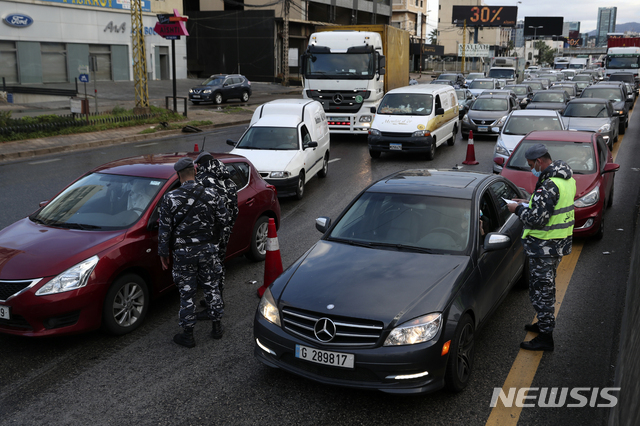 [AP/뉴시스] 14일 레바논 경찰들이 거리 검문소에서 특별 외출허가증을 검사하고 있다,