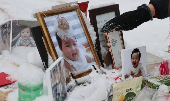 13일 오전 경기도 양평군 하이패밀리 안데르센 공원묘원에서 한 시민이 양부모의 학대로 생후 16개월 만에 숨진 정인 양을 추모한 뒤 주변에 쌓인 눈을 치우고 있다. 양평=연합뉴스
