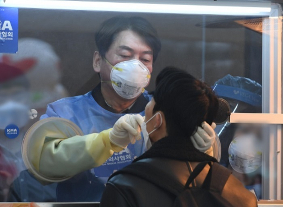 국민의당 안철수 대표가 15일 서울광장에 마련된 임시 선별검사소에서 의료 자원봉사에 나서 검체를 채취하고 있다.  [출처-연합뉴스]