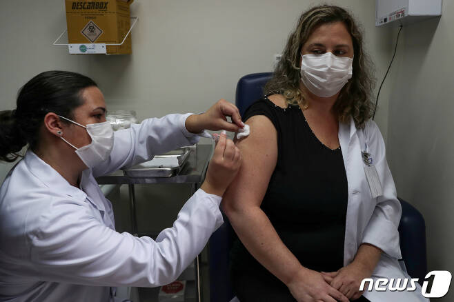 브라질에서 한 간호사가 여성에게 시노백 백신을 접종하고 있다. © 로이터=뉴스1